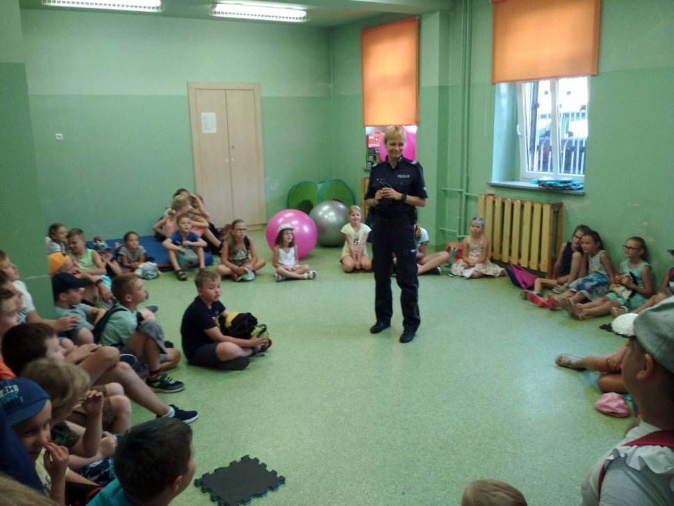 Fotografia kolorowa. Na zdjęciu widoczna policjantka prowadząca zajęcia z dziećmi. 