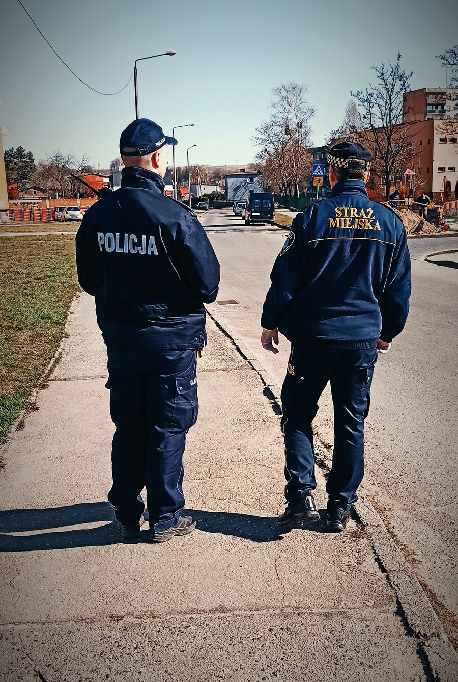 Na zdjęciu widoczny policjant wraz ze strażnikiem podczas patrolu. 