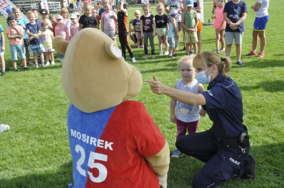 Na zdjęciu policjantka pokazująca coś dziecku