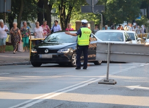 Zdjęcie przedstawia policjanta na skrzyżowaniu podczas regulacji ruchem